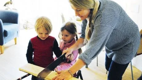 Scott och Scilla Schyberg Westbland sågar till brädbitar med hjälp av mamma Erica Westblad.