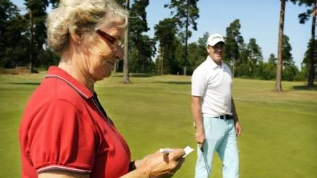 Nyhetens behag. Tommy Billberg puttar för glatta livet medan Liz Grauers antecknar resultatet. I anslutning till VT-golfen avgörs en puttävling.