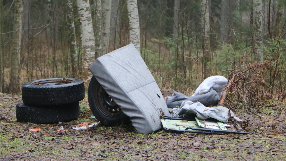På parkeringen intill friluftsområdet har någon eller några personer slängt gamla däck, en madrass, solstol och annat bråte.