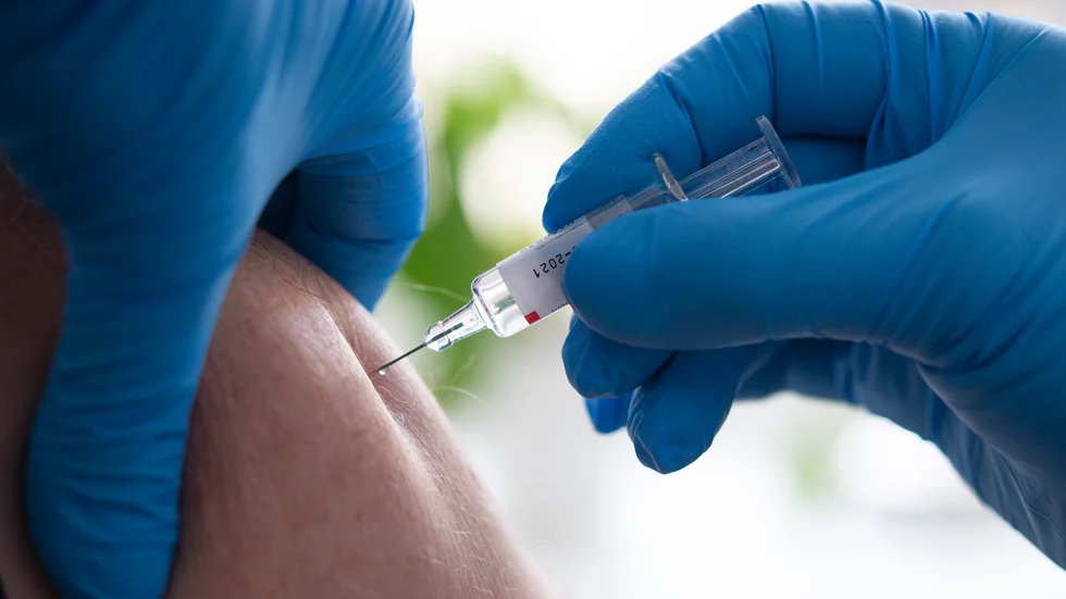 En person får en spruta med ett vaccin – dock inte mot covid-19. Arkivbild.