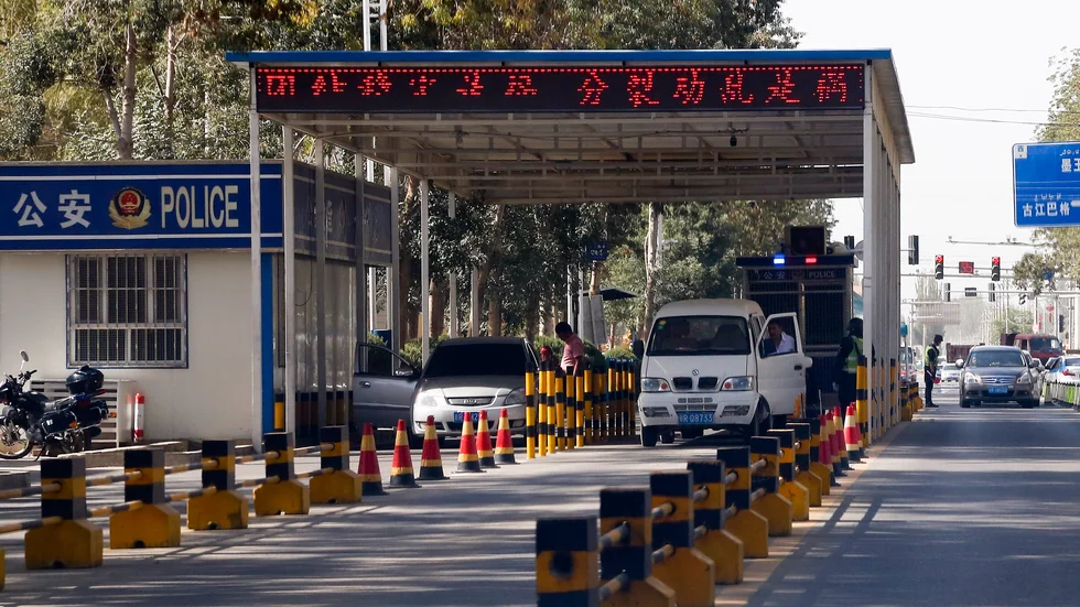Uigurer får sina fordon kontrollerade vid en poliskontrollplats i Hotan i Xinjiang. Arkivbild.