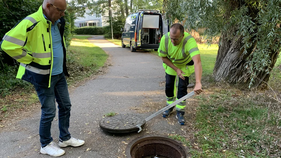 Driftschef Per Lundgren och rörinspektör Niklas Ceder bänder upp ett gatlock i Harg där ett av larmen sitter monterade. "Vi får ett sms som visar om nivåerna är för höga", säger Niklas Ceder.
