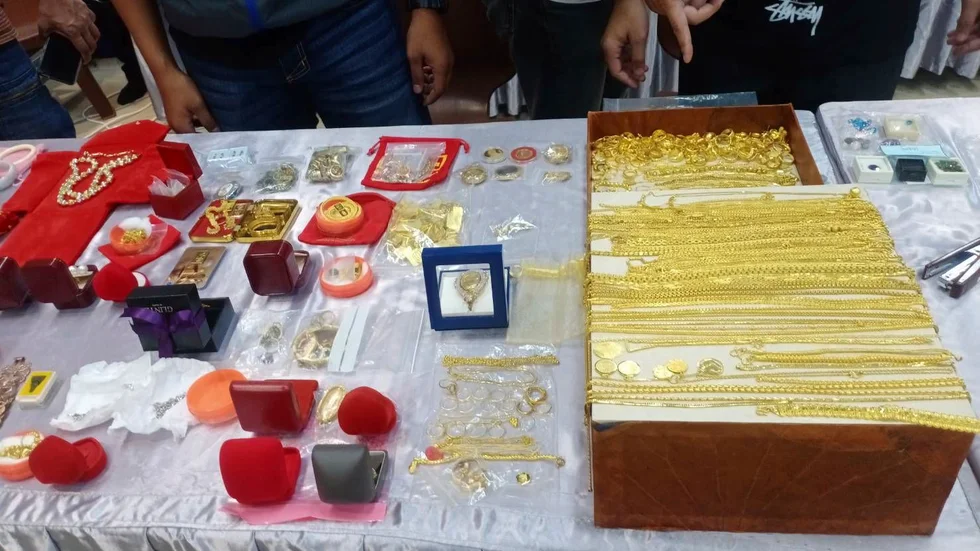 Polisen visar upp guld och andra smycken som beslagtogs vid räden mot buddisttemplet i den thailändska provinsen Nakhon Ratchasima.