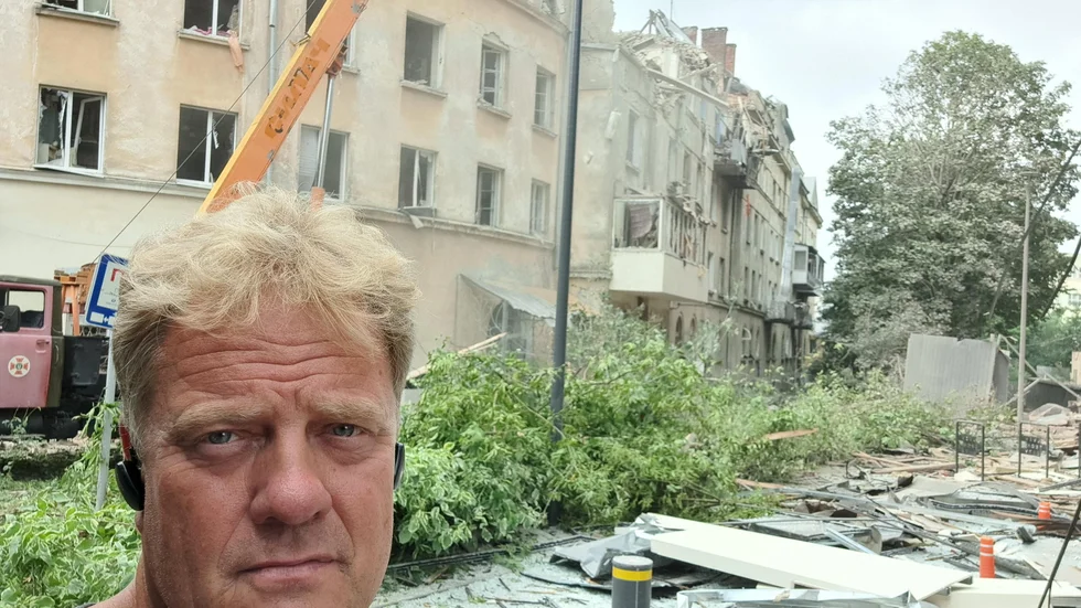 Svenske Börje Olsson vid den sönderskjutna byggnaden.