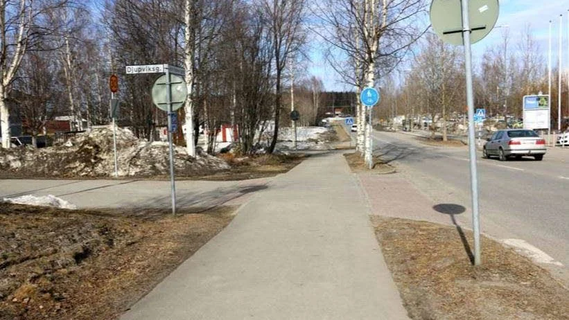 Detta är en genomgående cykelbana där en cyklist har företräde om en bil vill svänga in på Djupviksgatan. En liten förhöjning på vägen visar detta.