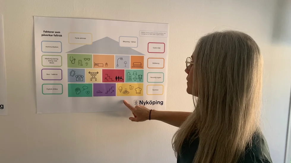 Arbetsteraputen Maria Karlsson Norén visar en plansch med instruktioner för att förebygga fallolyckor i hemmet. 