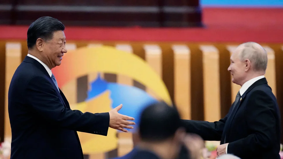 Kinas president Xi Jinping skakar hand med Rysslands president Vladimir Putin i Peking.
