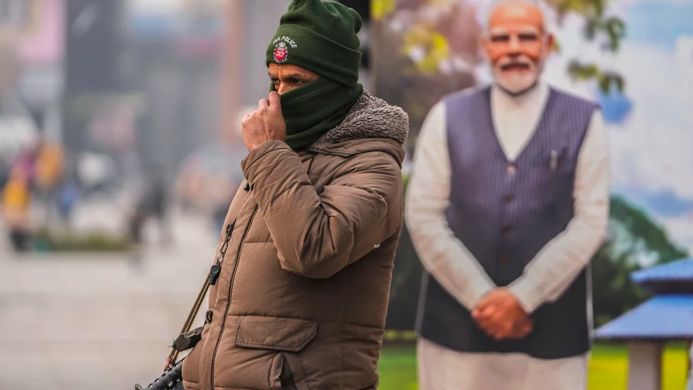 En polis, och bakom honom Narendra Modi i pappfigur, bevakar en marknad i Srinagar i den av Indien kontrollerade delen av Kashmir på måndagen.