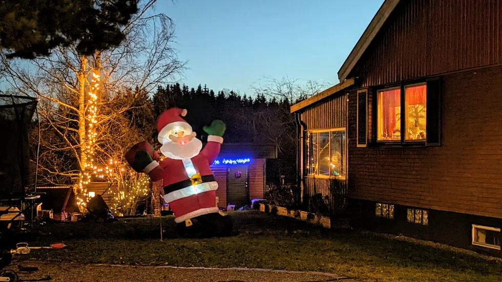 Vinkande jättetomte och hela trädgården upplyst med flera ljusslingor i  Lillkyrka.