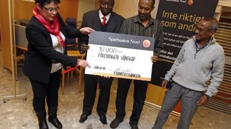 Kontorschef Anette Grundström delade ut 10 000 kronor till projektet Muco, här representerat av Michel Ntoto, Mohammed Yussuf och Ahmed Hassan.