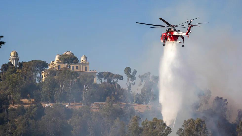 En helikopter vattenbombar branden på Monte Mario i Rom.