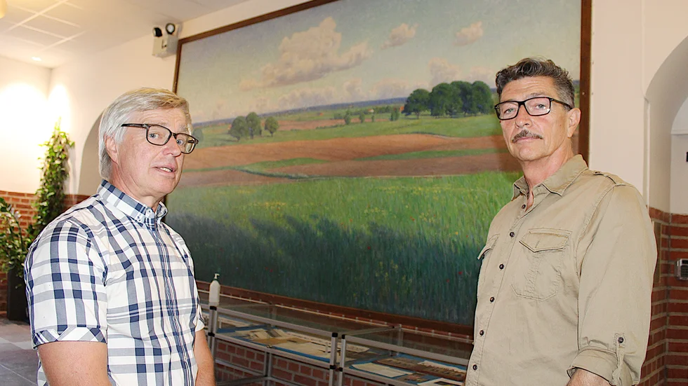 Hans Larsson, till vänster, diskuterar äggkastningen mot den stora oljemålningen i trapphuset i Katedralskolan med Johan Roos, konservator vid Östergötlands museum.