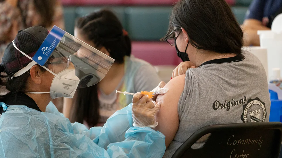 Systrarna Guadalupe Flores, 15 (höger) och Estela Flores, 13 får Pfizers-Biontechs vaccin i Los Angeles, Kalifornien.