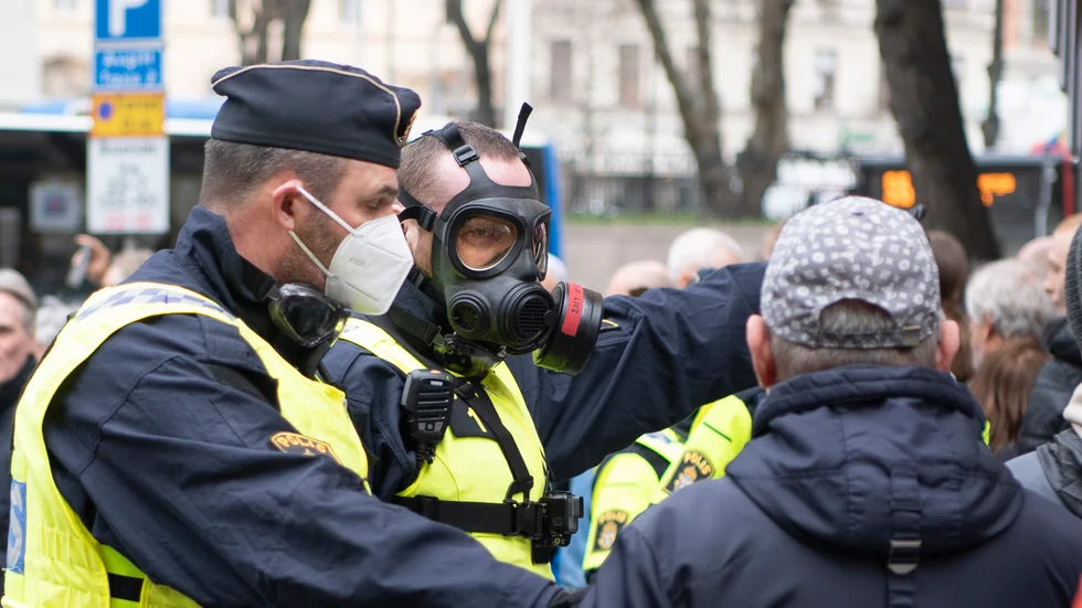 Polisen kommer framöver att använda sig av en militär skyddsmask i kontakt med allmänheten, som här i samband med en demonstration i Stockholm. Det är inte någon av poliserna på bilden som medverkar i vår artikel.