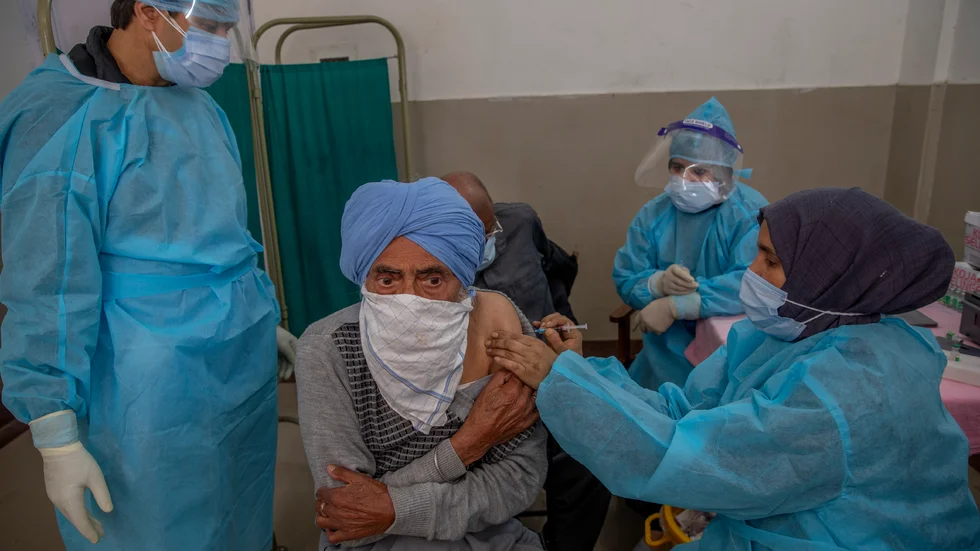 En man får covid-vaccin på en vårdcentral i Srinagar i Kashmir.