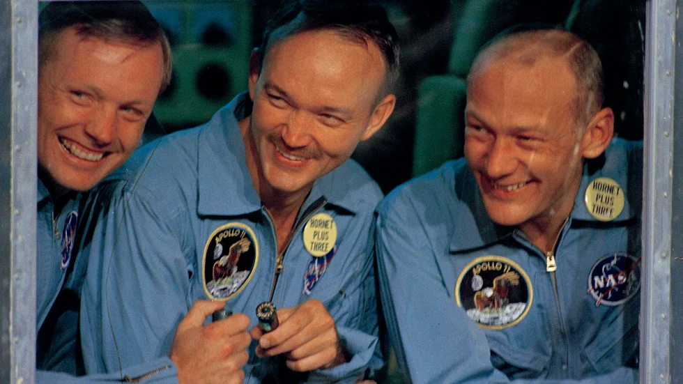 Apollo 11-astronauten Michael Collins (mitten) har avlidit av cancer. På bilden som togs ombord på det amerikanska örlogsfartyget USS Hornet efter rymdfärden 1969, svarar han på pressens frågor tillsammans med kollegorna Neil Armstrong (vänster) och Buzz Aldrin inifrån ett karantänsrum.