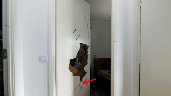 Här är polisens bild på den sönderslagna dörren till sovrummet där sonen och mamman gömde sig under attacken på familjen.