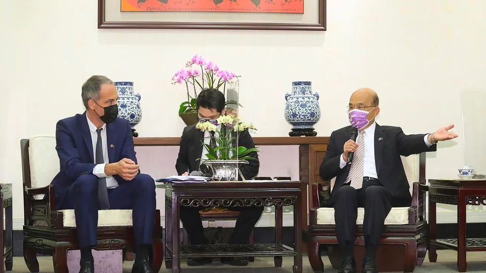 EU-parlamentsledamoten Raphaël Glucksmann (till vänster) talar via tolk (i mitten) med Taiwans premiärminister Su Tseng-Chang (till höger).