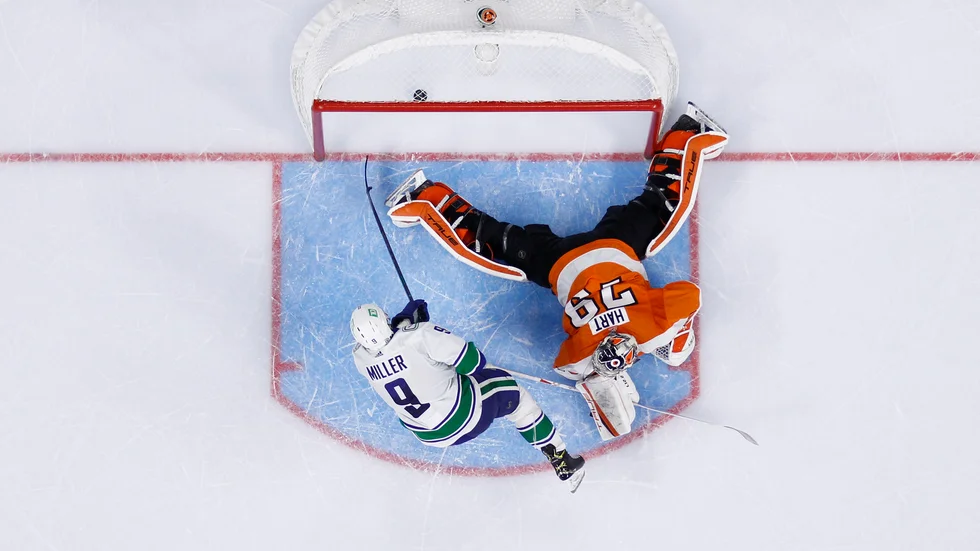 Vancouvers JT Miller sätter en av straffarna mot Philadelphia med Carter Hart i målet.