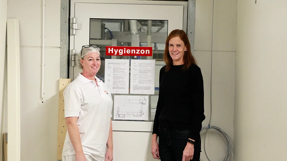 Lotta Burman och Lilian Nilsson är båda otroligt glada över att produktionen snart äntligen är igång. Bakom dörren ligger nya fabriken som de längtar efter att snart få visa upp.
