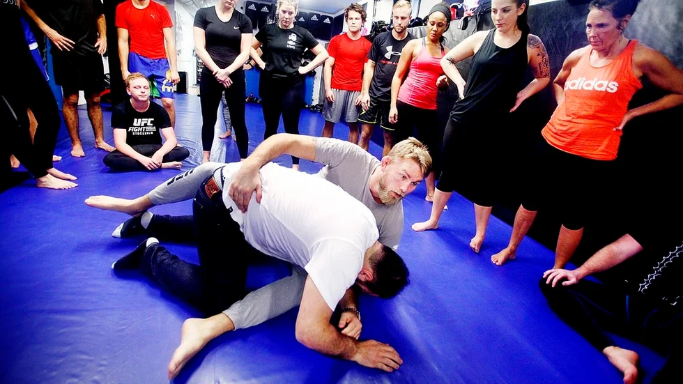 Alexander "The Mauler" Gustafsson visar hur en av övningarna på söndagens andra träningspass ska utföras. De övriga deltagarna lyssnar intresserat.
