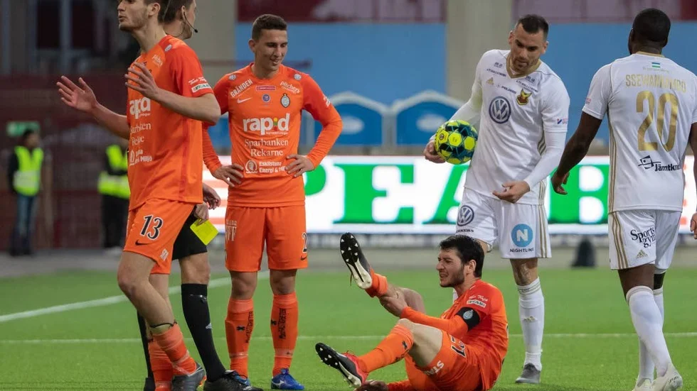 AFC-kaptenen Anel Rashkaj blev liggandes i gräset efter en duell med Östersunds Dino Islamovic (med bollen), men varnades för filmning.