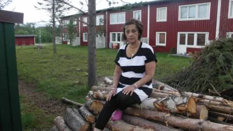 I framtiden ska inga träd fällas på Topbostäders områden förrän samrådsmöten skett.  Anita Karlsson sitter på vedhögen som blev kvar sedan lillskogen höggs ner. FOTO: Marie Ridderström