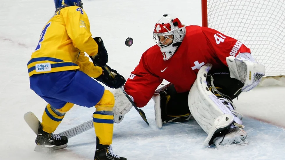 Goalkeeper Florence Schelling of Switzerland (41) blocks Jenni Asserholt of Sweden's (4) shot on the goal during the second period of the women's bronze medal ice hockey game at the 2014 Winter Olympics, Thursday, Feb. 20, 2014, in Sochi, Russia. (AP Photo/Julio Cortez)