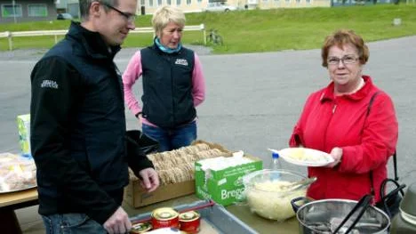 Per Holma och Annelie Vinsa från Kirunabostäder ser till att besökaren Majvor Johansson tar för sig av surströmming. Kirunabostäder hade bunkrat upp med tusen strömmingar till sitt öppet hus. FOTO: Hans Sternlund
