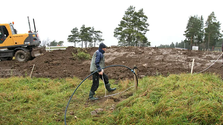 Martin Zetterholm och Timmy Wernersson tillsammans med Peter Wernersson justerar crossbanan på Sviestad.
