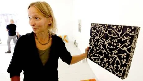 Kikki Schöpper visar en av sina bilder där relieferna fungerar som omväda hällristningar och berättar om tillståndet i världen. foto: tommy söderlund