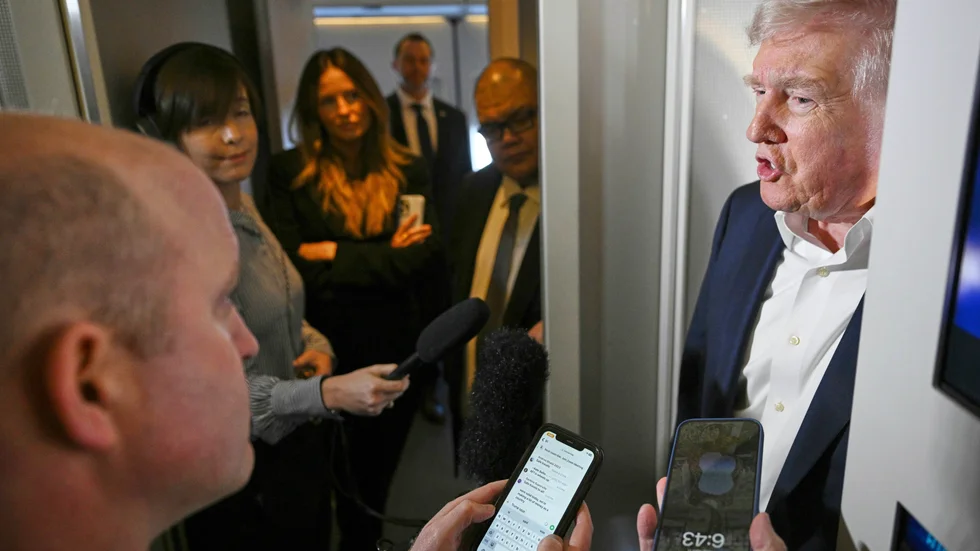 President Donald Trump talar med reportrar ombord på presidentflyget Air force one.