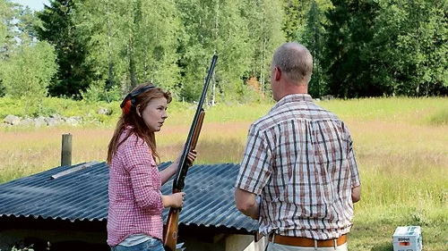 Alicia Karlsson får hjälp av Lars Persson innan hon sätter igång med lerduveskyttet.