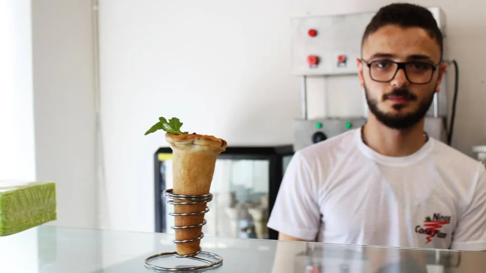 Adnan Alo serverar en nygräddad pizzastrut.