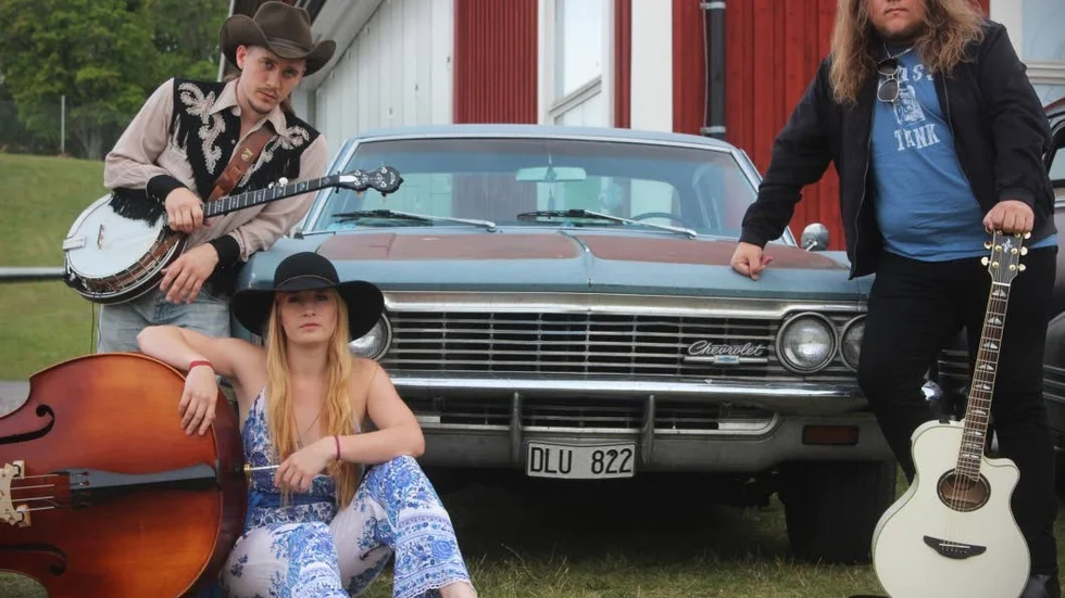 Grass Tank (Gustav Hasting (sång, banjo), My Weidel (kontrabas) och Andreas Lindgren (gitarr, sång)) besöker Mantorps bibliotek på onsdagskvällen.