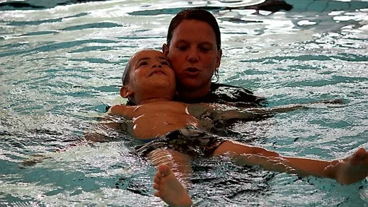 Här lär Emma Pil ut hur 7-årige Tim ska känna hur det känns att flyta, något av de första som barnen på sommarsimskolan får lära sig.