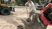 Mikael Sylvin förbereder nätstolparna som ska stå fast i marken med hjälp av cement.                           FOTO: TITTI OLOVSSON