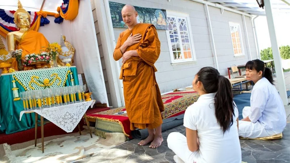 Många kommer till buddhisttemplet för att lära sig mer om meditation, som Chana Emsan och Jiraporn Sutiswan. Här framför munken Phra Tha-Ong Piamthong.
