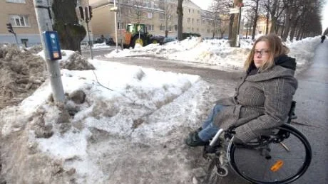 Här är det tvärstopp för rullstolen. Det är helt omöjligt att nå knappen vid övergångsstället för Jenny Larnemark.  Snömassorna gör att hon helst håller sig hemma. Foto: Janne Forsby