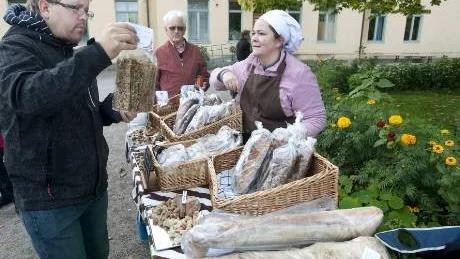 Daniel Aröd köper ekologiskt hälsosamt bröd av Paulina Rather från Finbageriet Kamraterna, som deltog i Rudolf Steinerskolans skördefest.