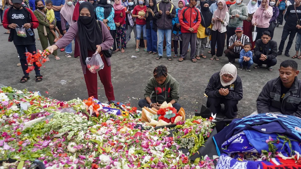 Folk lägger ner blommor utanför fotbollsstadion där tragedin inträffade.