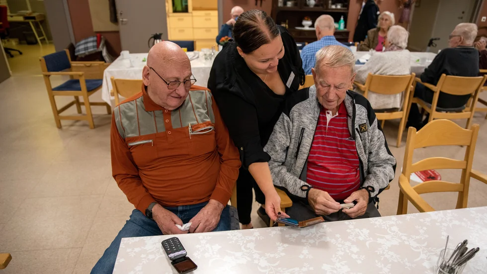 Sören Andersson och Ulf Boman får hjälp med sina mobiltelefoner av Hanna Hedlund, kommunens första digitala lots.