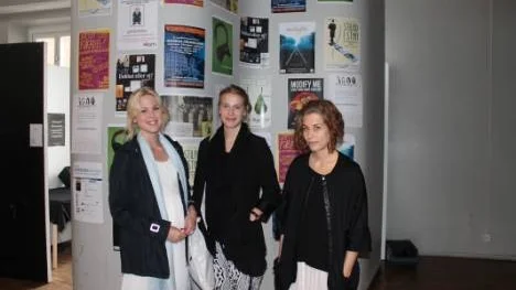 Josefin Persson (mitten) och Lina Jaensson (t.h) framför affischer av produktioner som den avgående klassen har skapat under de tre åren på KSM. Till vänster Nathalie Järlehag, som också varit med i arbetet.