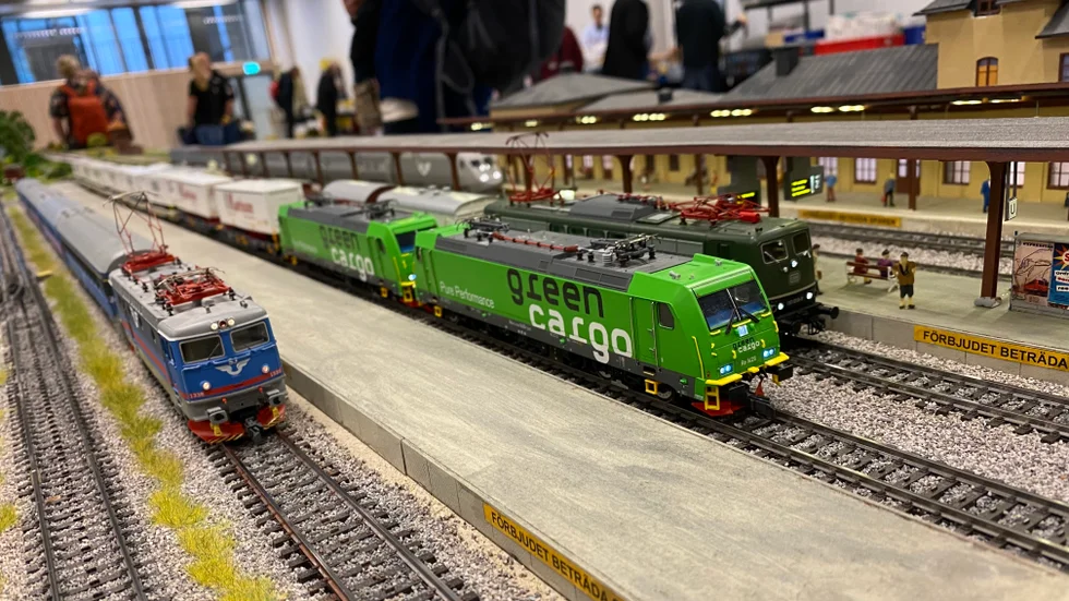 Bakom tågen syns en miniatyr av Uppsala centralstation. 