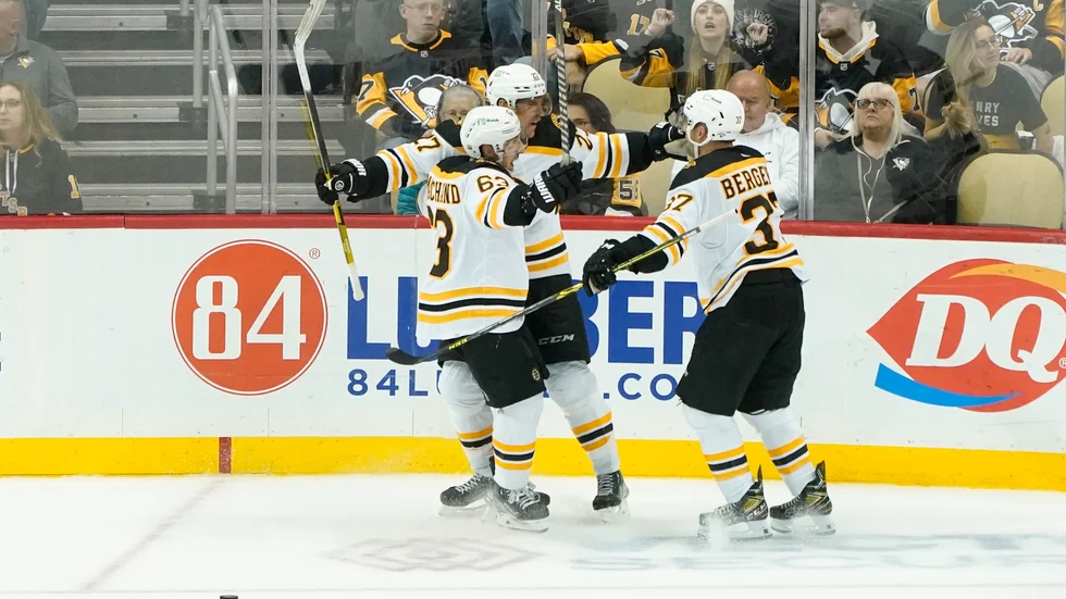 Bostons Hampus Lindholm (mitten) kramas om av Brad Marchand och Patrice Bergeron efter segermålet.