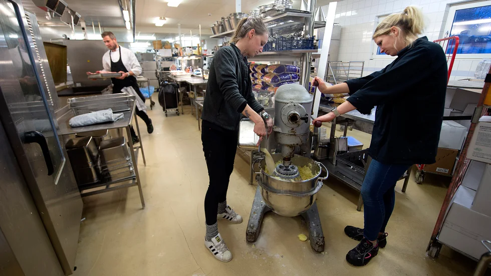 Matilda Eriksson och Malin Svensson gör i ordning 150 kilo potatismos till falukorven som serveras första middagen. I bakgrunden syns Mattias Cypriansen Carlsson som driver cateringfirman.