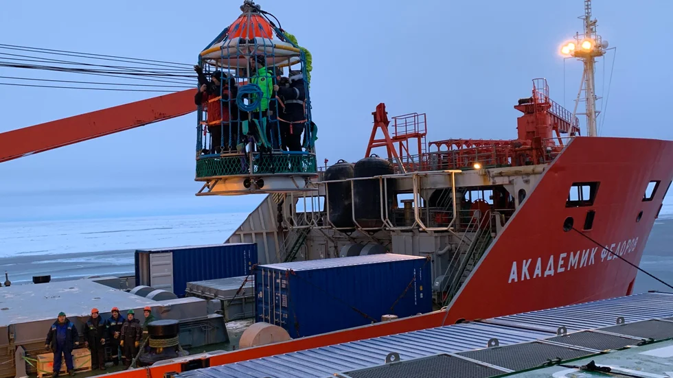 Forskare lyfts över till ett ryskt fartyg vid en expedition till Nordpolen 2019, där Pauline Snoeijs Leijonmalm deltog.