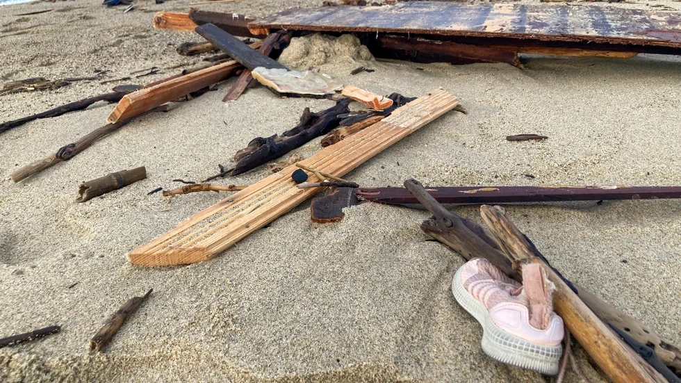 Kläder och leksaker bland de vrakspillror som flutit i land på stranden i den syditalienska staden Crotone efter helgens förlisning.