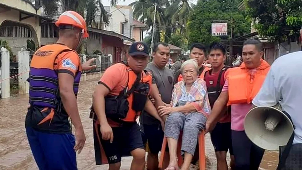 En äldre kvinna får hjälp av den filippinska kustbevakningen i provinsen Misamis Occidental på ön Mindanao i den södra delen av landet. Bilden är från i måndags.