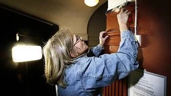 Agneta Pettersson, antikvarie på Upplandsmuseet, skrapar fram ursprungsfärgen på väggarna i Biologiska museet.
